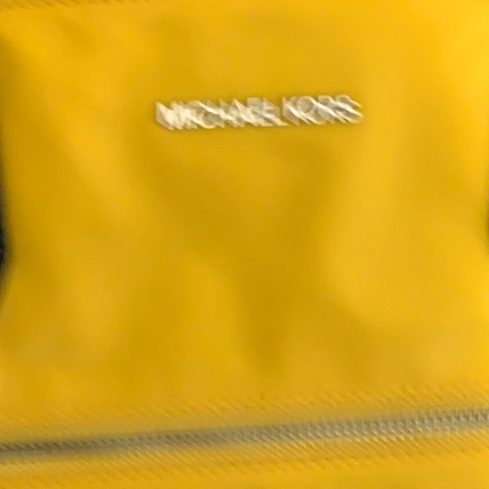 Michael Kors pocket book yellow with black straps. Like a satin leather.